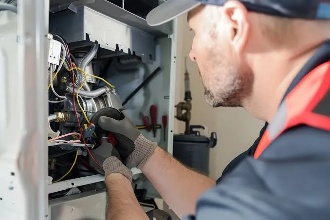 Gloved technician inspecting heating-system controls
