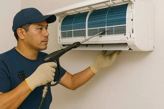 Technician cleaning an indoor wall-mounted air conditioner