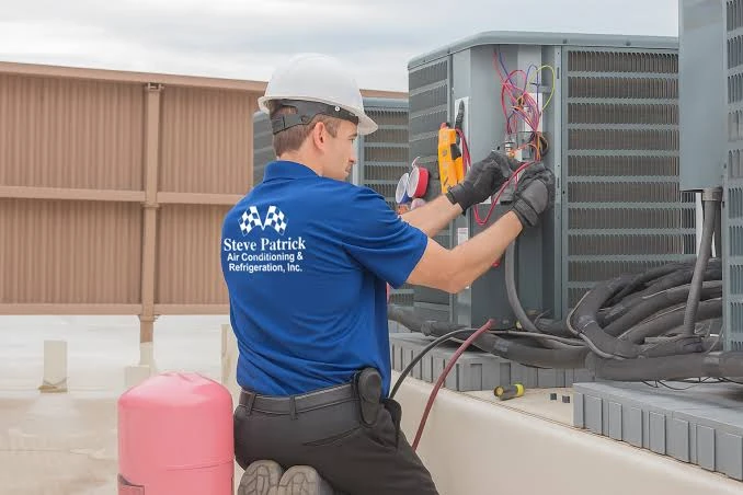 Technician testing an outdoor HVAC unit with diagnostic equipment