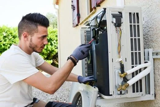 Technician inspecting the controls of an outdoor air-conditioning system